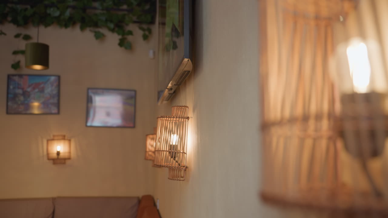 Beautiful view of glowing light bulbs inside wooden decorative frames on wall beside television screen displaying realistic animated fireplace flame