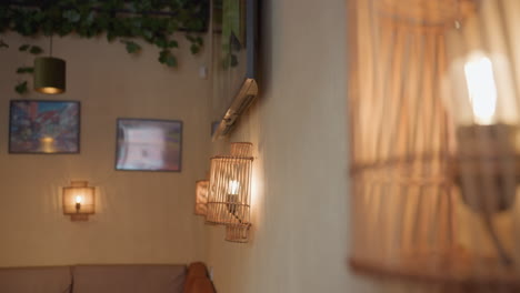 beautiful view of glowing light bulbs inside wooden decorative frames on wall beside television screen displaying realistic animated fireplace flame