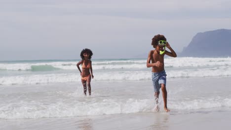 african american children wearing scuba goggles playing at the beach