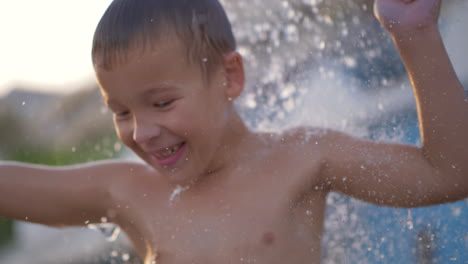 Niño-Alegre-Bailando-Bajo-La-Ducha-De-La-Playa