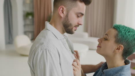 joven amorosa apoyando la cabeza en el pecho de su novio mientras él la abrazaba en casa