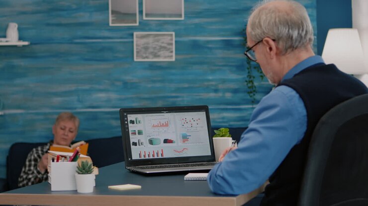 Middle aged senior older man analysing business graphs