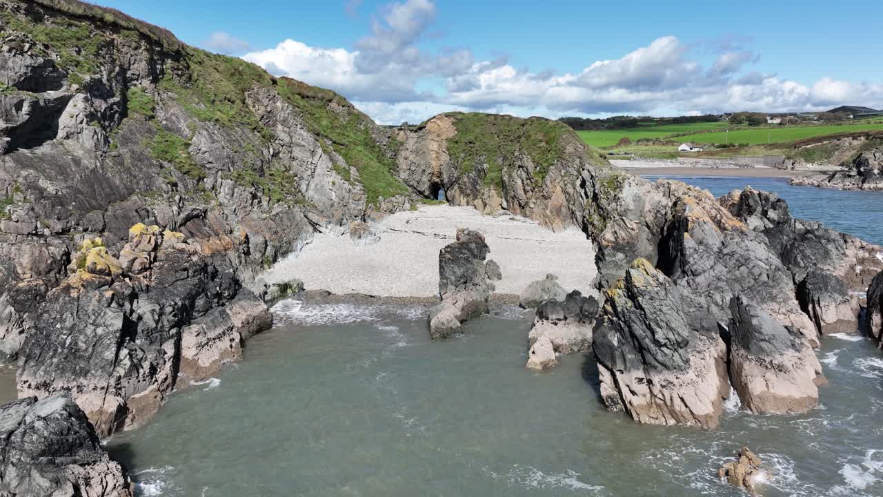 Drone Flying into hidden cove on the Copper Coast waterford on a calm warm summer day