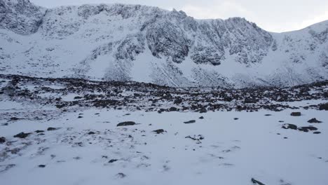 Aerial-drone-footage-slowly-approaching-the-headwall-of-Coire-an-t-Sneachda-in-the-Cairngorm-mountains-of-Scotland-in-snow,-ice-and-full-winter-mountaineering-conditions