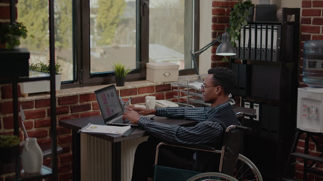 Lavoratore afroamericano con disabilità cronica che usa un laptop