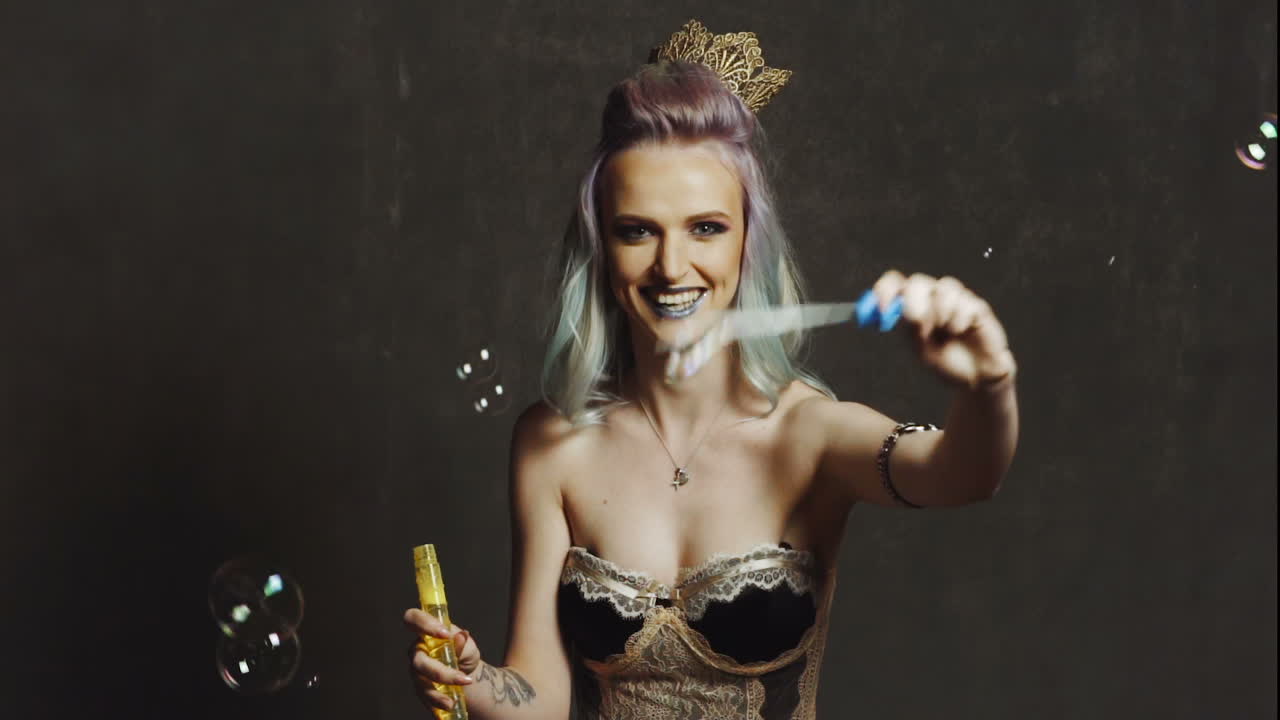 Woman blowing soap bubbles. Young beautiful girl blowing bubbles in a studio