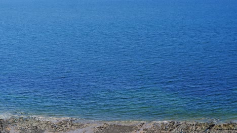 beautiful clear blue sea water in gower peninsula on sandy rocky beach. holiday tourism nature footage.