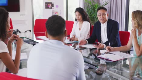 senior businessman discussing with young business people in meeting room in modern office