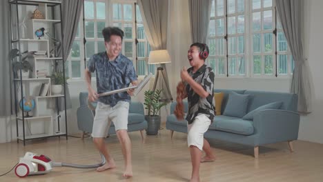 cheerful young asian father and son cleaning up they home and singing