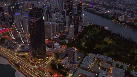 Autopista-Pacífica-Bien-Iluminada-Y-Autopista-Junto-Al-Río-Con-Edificios-De-Gran-Altura-En-La-Orilla-Del-Río-Brisbane-En-Brisbane,-Queensland-Por-La-Noche