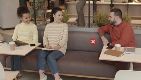 man starting conversation with women in cafe