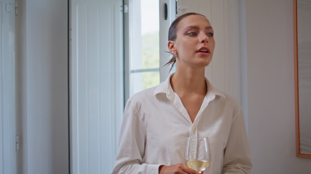 Primo piano di giovani che comunicano a casa. Uomini e donne rilassati che tengono in mano calici di vino.