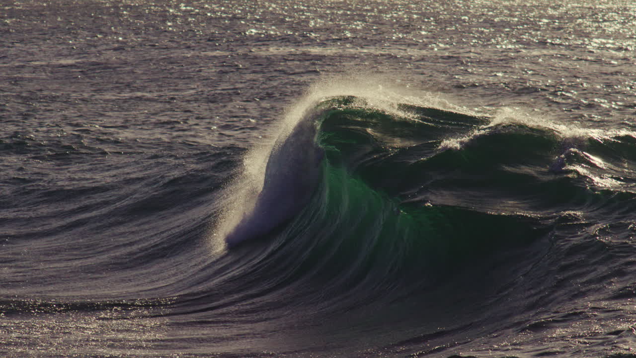 Textured surface shimmers as wave recedes under calm evening sky, soft tide reflections