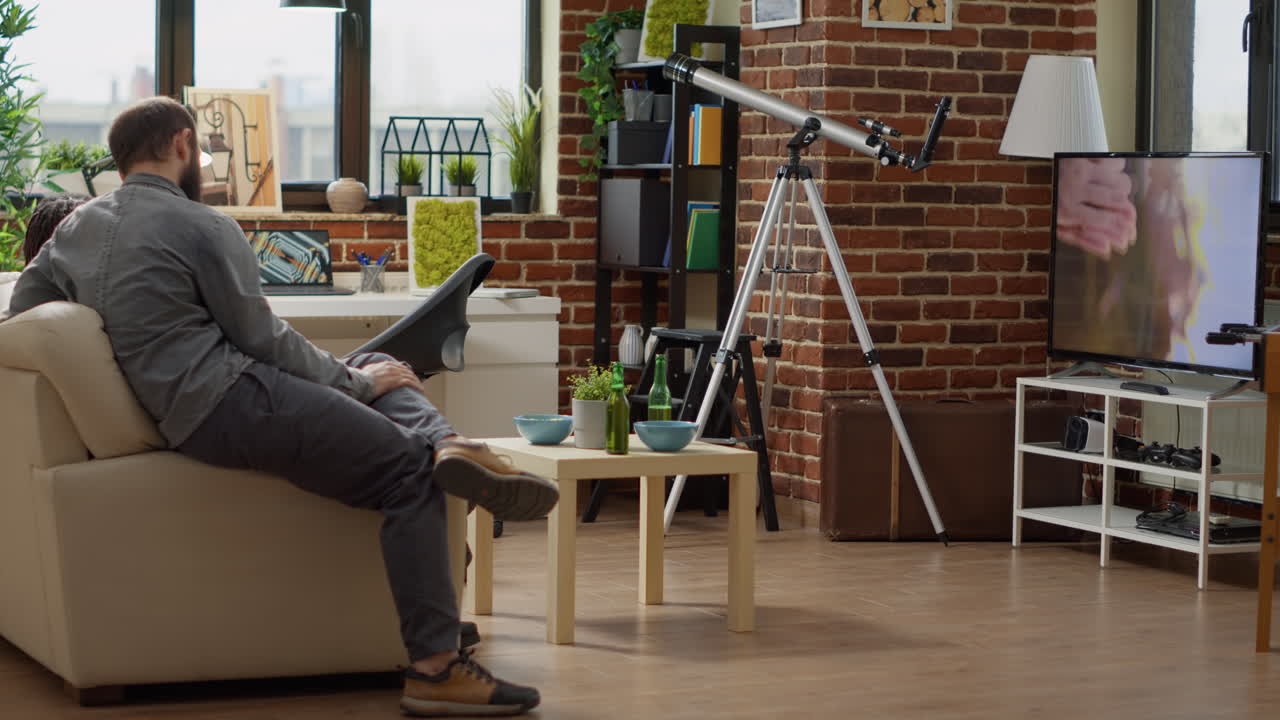 Cheerful friends having fun with movie on television screen