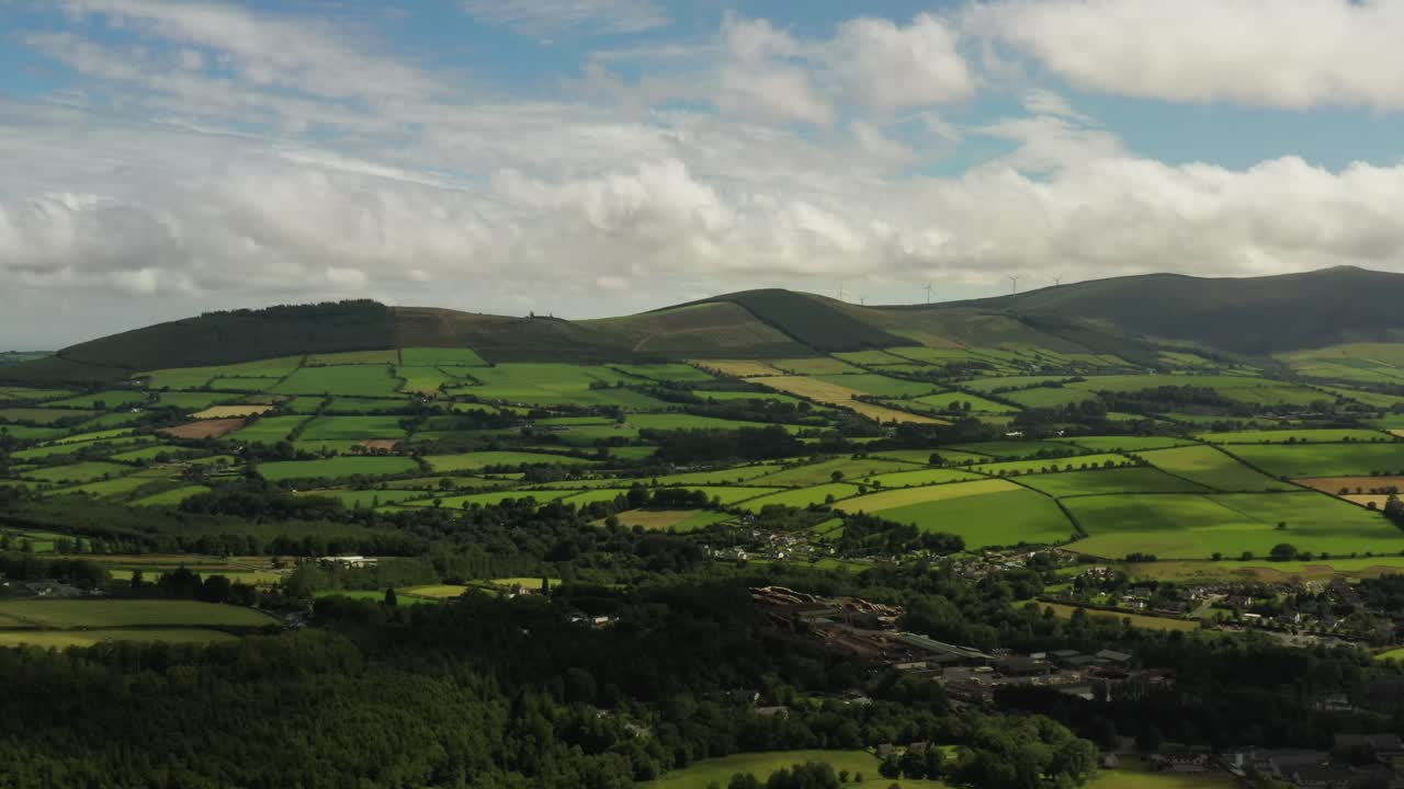 paisaje rural irlandés, aughrim, wicklow agosto de 2020, el dron rastrea gradualmente paralelo al pueblo mirando al sur hacia las colinas superiores de ballycoog