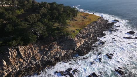 Pescadero-Point-'s-rocky-shoreline-peninsula-along-Pebble-Beach,-California---dynamic-aerial-reveal