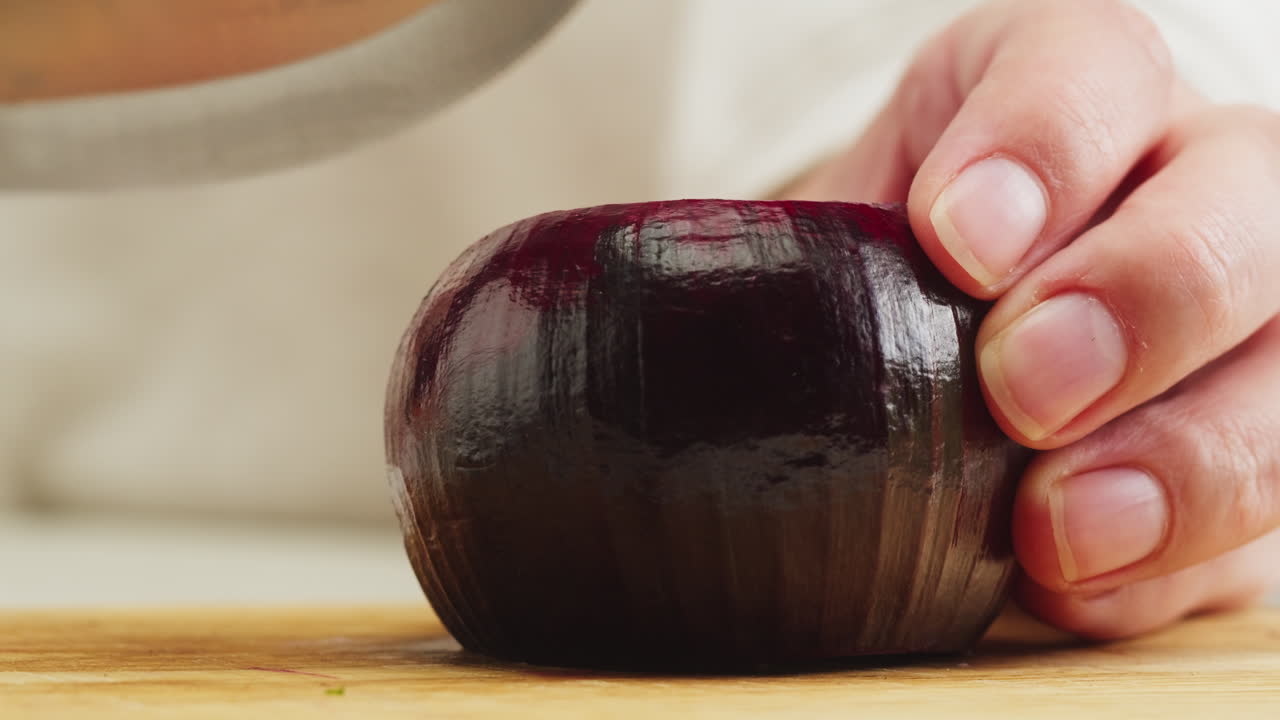 Close Up of Hands Slicing Red Onion on Cutting Board