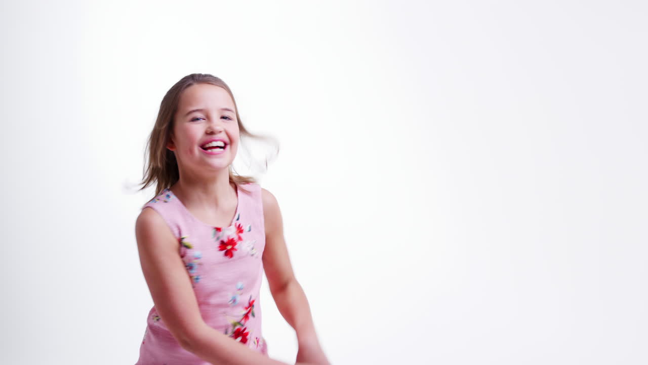 Chica Saltando Y Posando Contra Fondo De Estudio Blanco