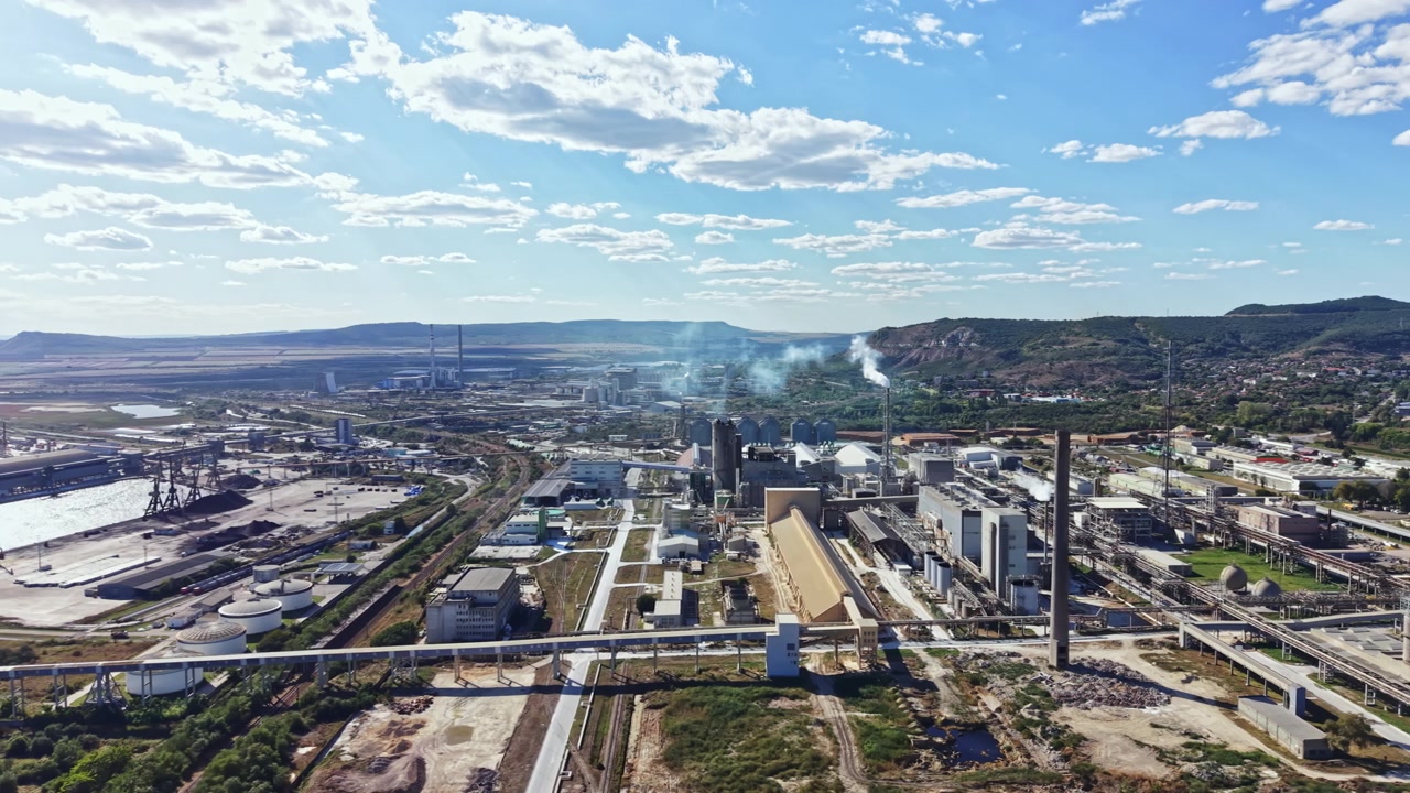 Área industrial com fábricas e maquinário em uma paisagem sob um céu limpo
