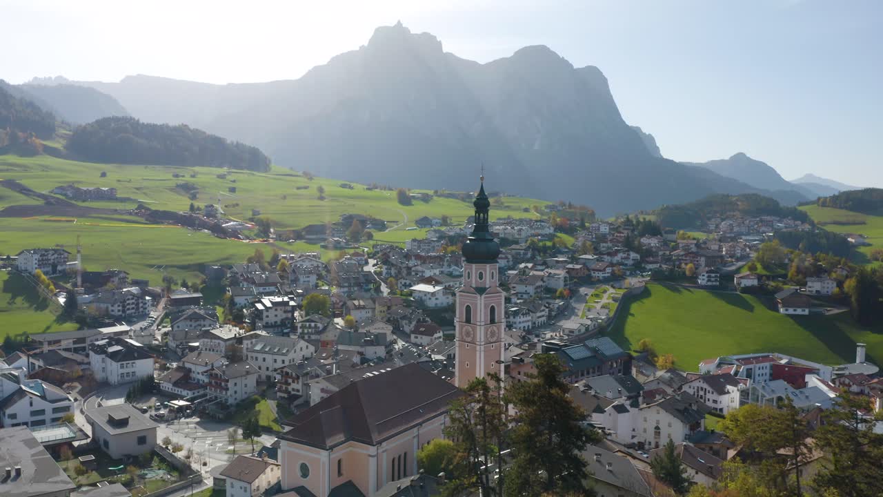 drone vuela más allá de la torre de la iglesia en el pueblo del tirol del sur de los dolomitas italianos