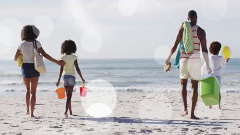 Animation-Von-Flecken-über-Einer-Afroamerikanischen-Familie,-Die-Am-Sonnigen-Strand-Spaziert