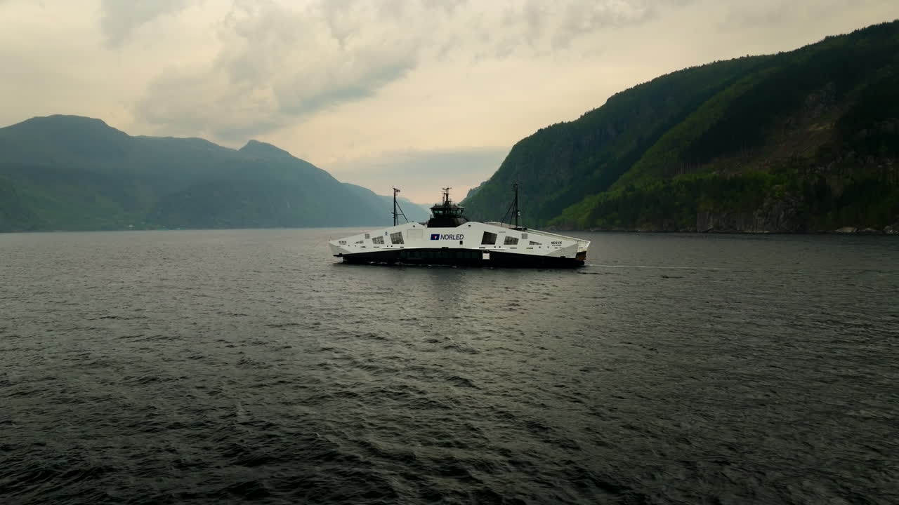 Hydrogen-powered ferry in Hjelmeland fjord, sustainable transport and green technology, Norway. Aerial lateral view at low altitude