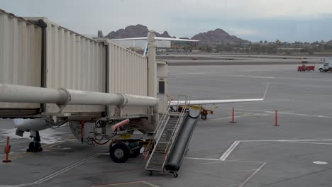 Airport-Employee-Walks-into-Jet-Bridge-from-Airstairs-just-off-the-Airport-Apron-of-Phoenix-Sky-Harbor-International-Airport-in-Arizona-on-Overcast-Day---4K