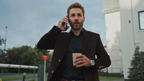 businessman talking on phone and drinking coffee