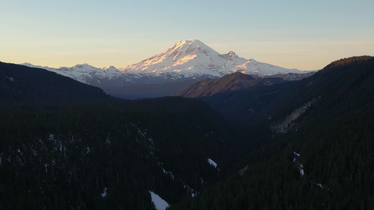 Aerial view of Mt. Rainier at sunset, Aerial ascending with forest