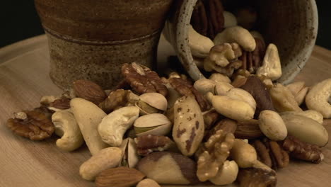 Delicious, healthy snack: Assorted roasted nuts rotating in black room