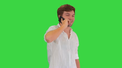 행복한 젊은이가 휴대 전화로 이야기하고 녹색 화면에서 미소 짓고, 크로마 키
