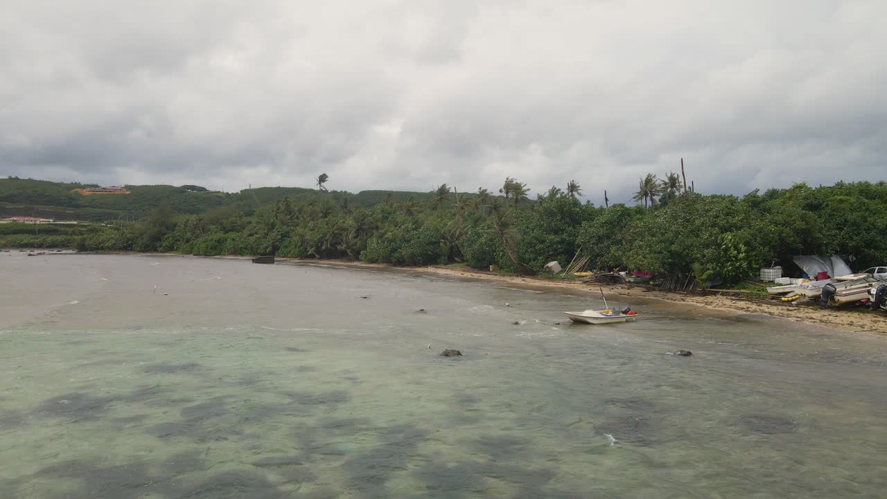 bote pequeño meciéndose en las olas durante una tormenta en una isla tropical