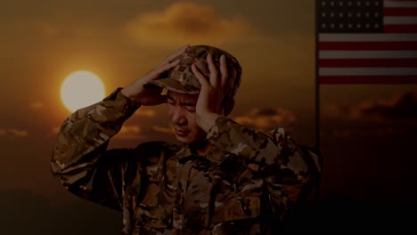 close up of asian man soldier having a headache while standing with flag of the united states, sunset time