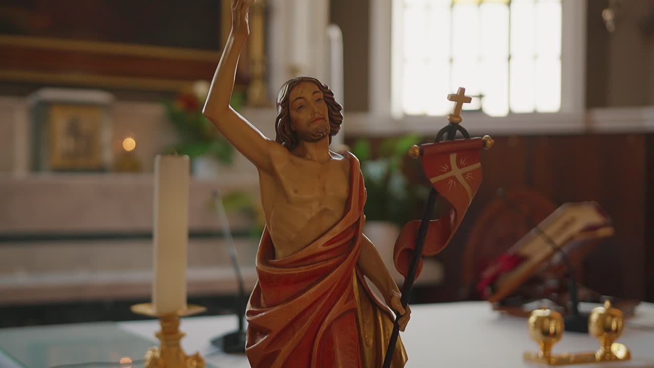 Statua religiosa in un tranquillo interno di chiesa con candele accese.