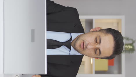 Vertical-video-of-Home-office-worker-man-working-with-concentration.