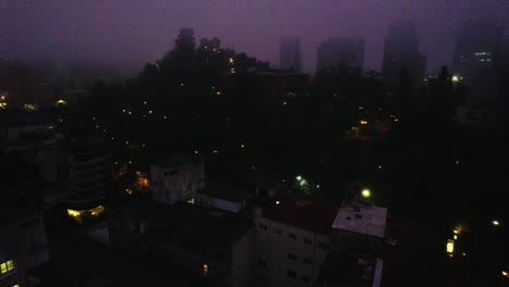 aerial view dolly in establishing night view of lastarria neighborhood and santa lucia hill, desolate and gloomy perspective, cloudy morning