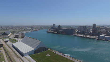 an aerial crane shot showcasing the bustling port of necochea and the scenic quequen grande river, highlighting the vibrant activity and natural beauty of this iconic argentine location.