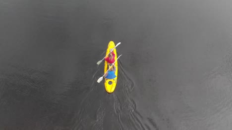 animation of caucasian people grumbling in a yellow canoe from a high view angle