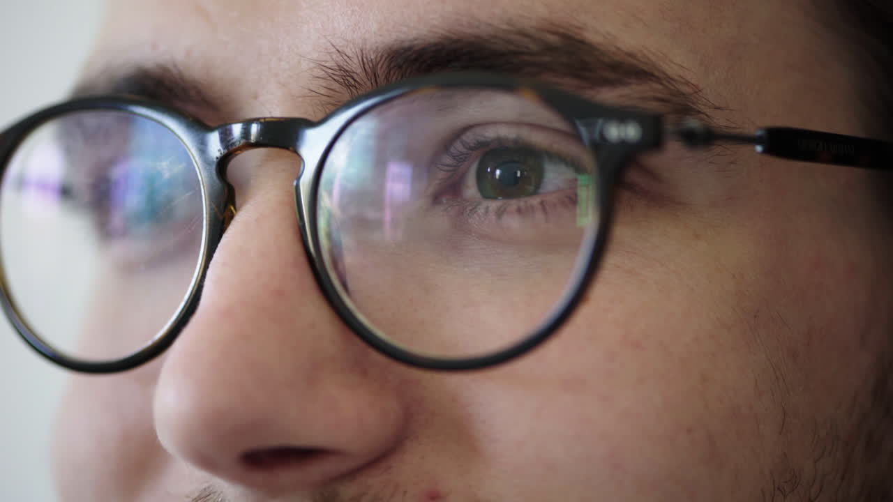 primer plano de los ojos de un joven que se abre con gafas buscando un concepto de vista feliz y saludable