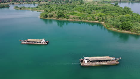 Industrielle-Sandtransportschiffe-Segeln-Langsam-Entlang-Des-Flusses-Mit-Bäumen-Am-Wasser