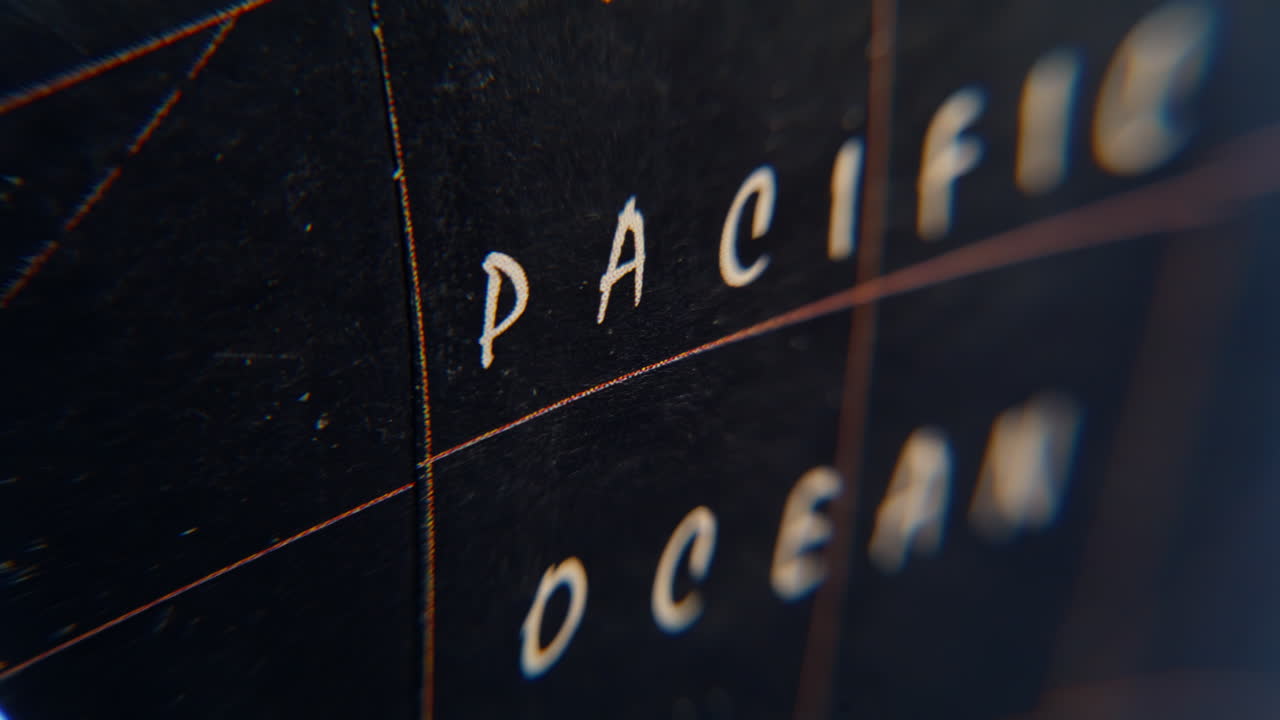 Pacific ocean designation globe blurred macro view. White geographical name