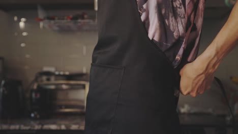 chef tightening his apron on its back before cooking