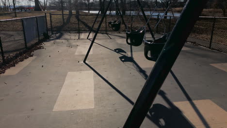 Empty toddler swing set in park, winter time