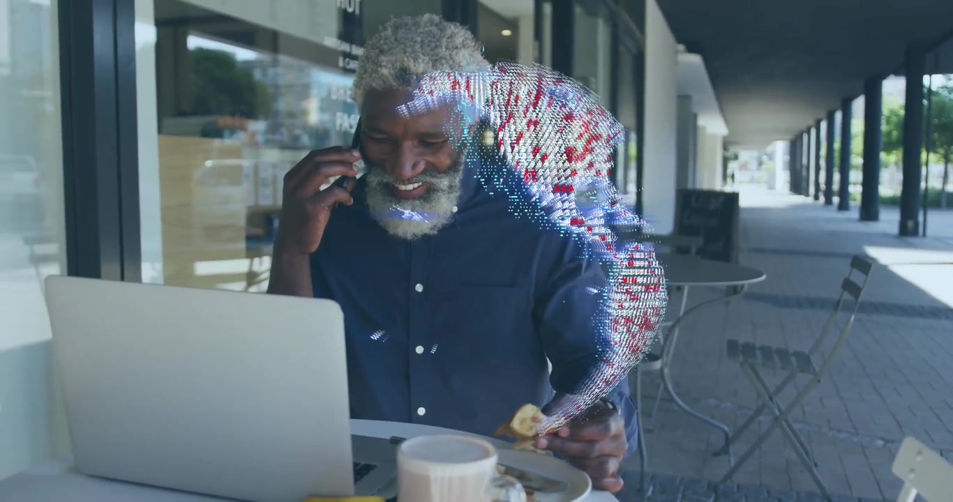 Uomo di mezza età in un caffè che chiama con lo smartphone discutendo dati mentre digita sul laptop, con un globo tecnologico che si dissolve.