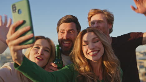amigos felices haciendo selfies con teléfonos inteligentes celebrando en un techo soleado de cerca.