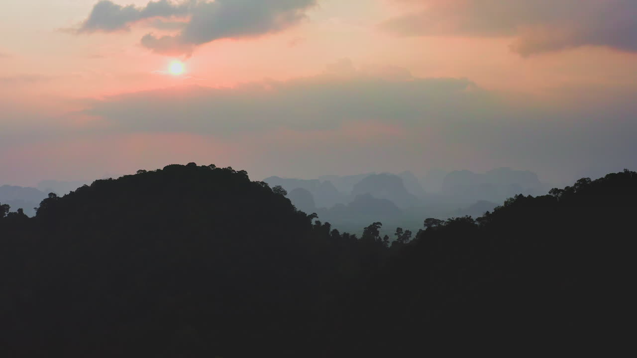puesta de sol nebulosa sobre la silueta del paisaje montañoso de la selva, tailandia