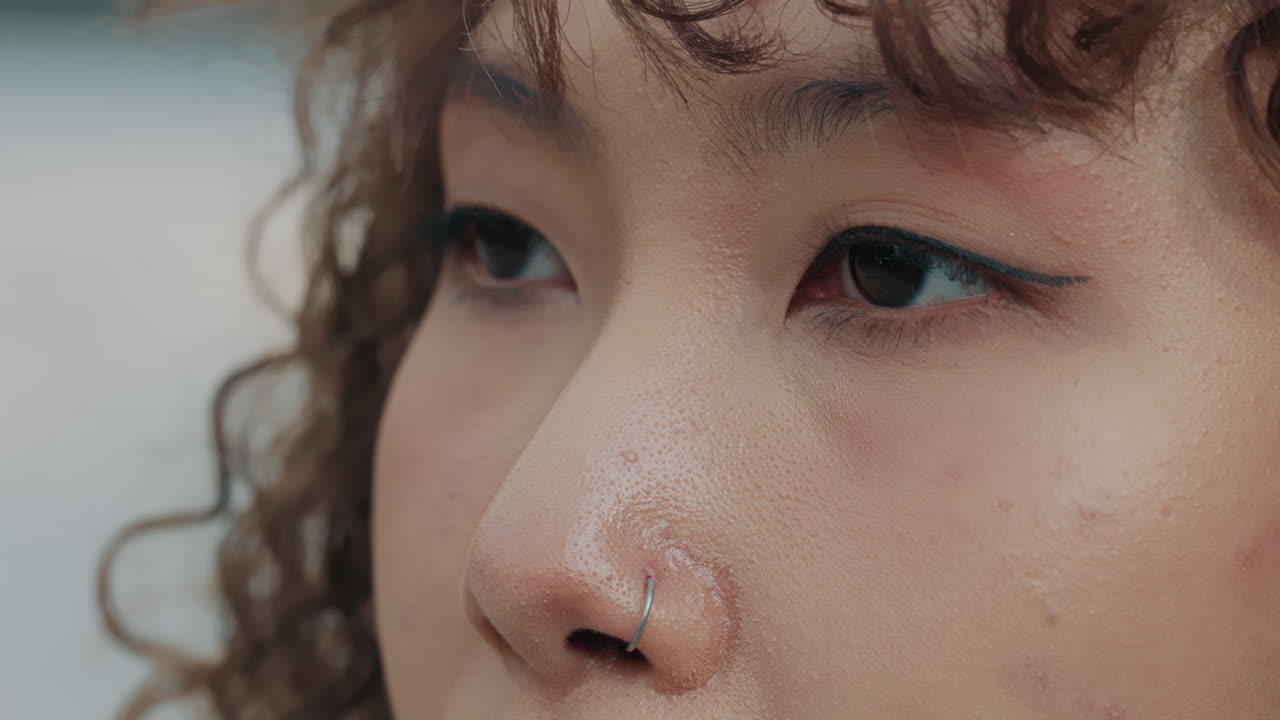 Close-up portrait of a woman with nose ring and makeup