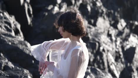 graceful lady in white tulle dress striking a pose on sunny beach