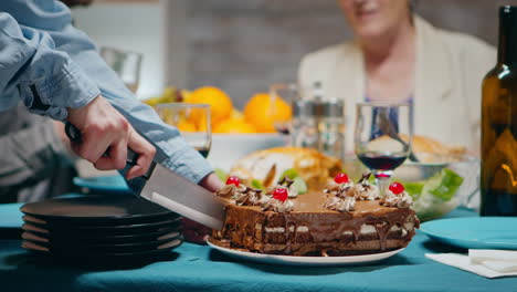 un primer plano de una mujer joven cortando un pastel delicioso.