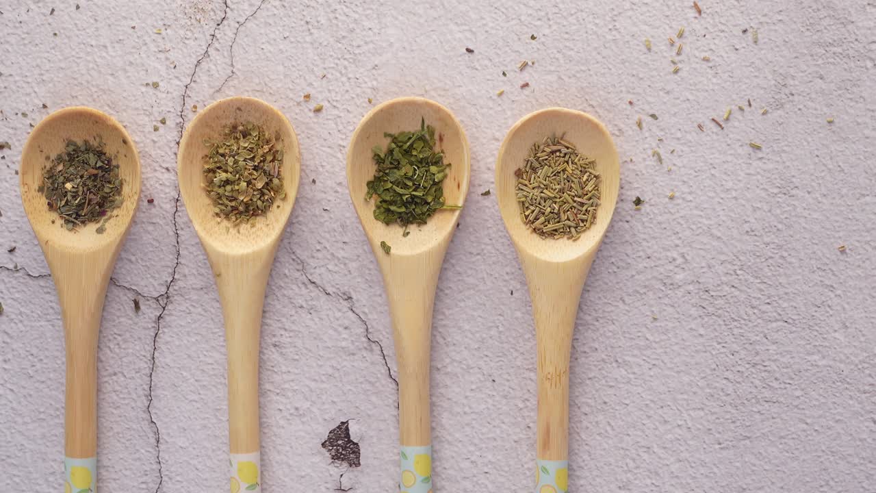 Assortment of dried herbs in wooden spoons